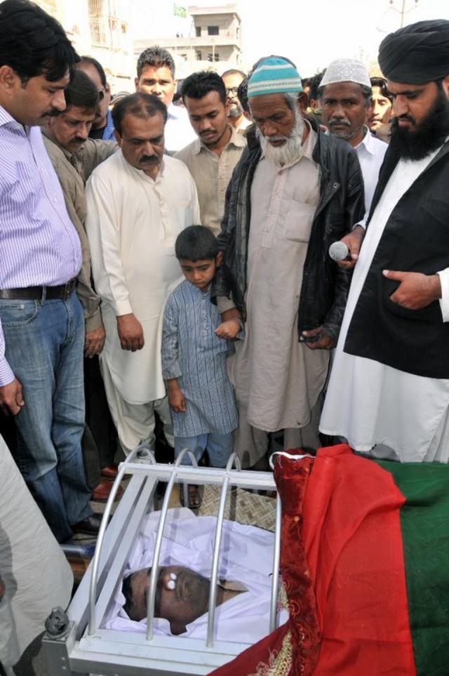 Salman's son standing next to his father's coffin.